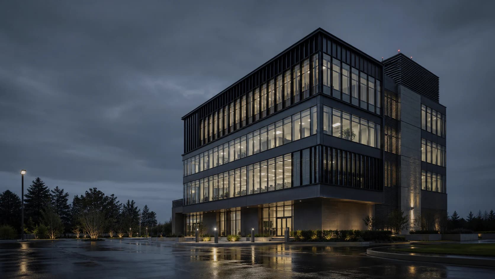 Modern commercial building with a steel and glass facade and softly illuminated interiors at blue hour