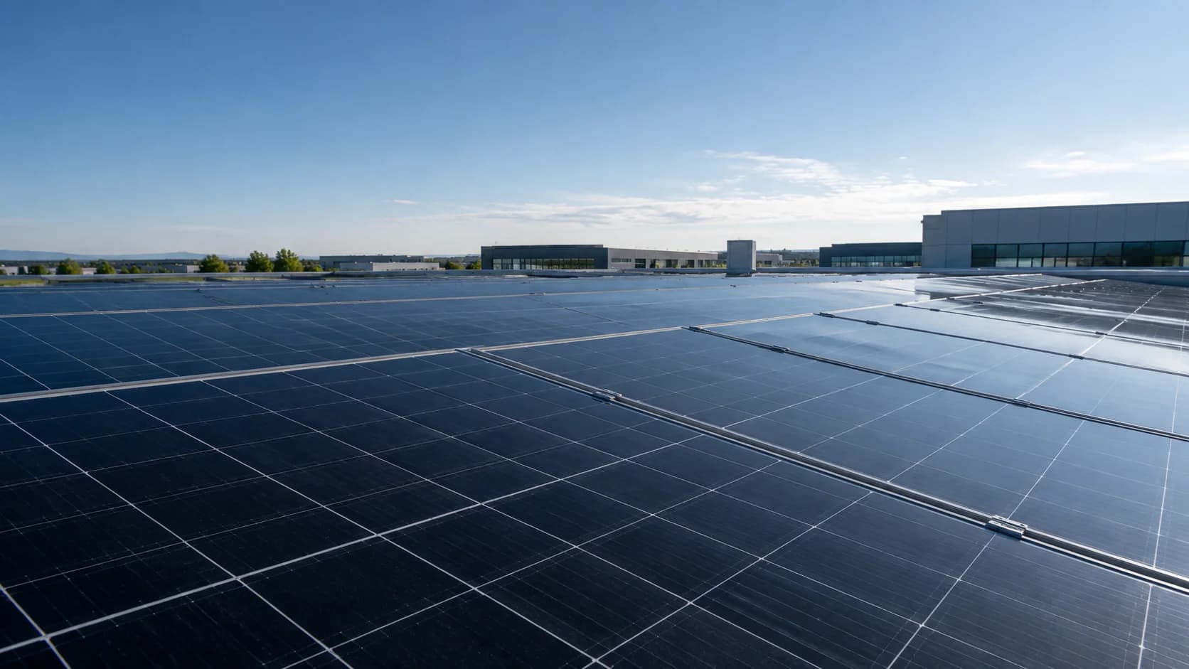 Commercial rooftop photovoltaic array in clear daylight, with the surrounding architecture visible